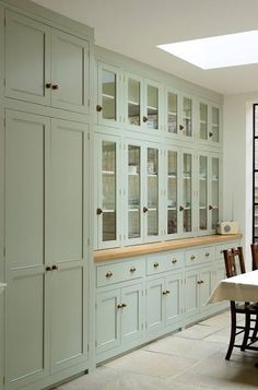 a dining room table and chairs in front of cabinets