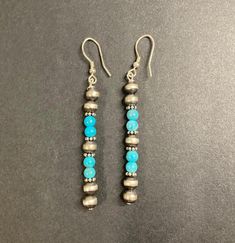 Handcrafted Navajo Jewelry Turquoise Beads and Navajo Pearls Dangle Earrings   Handcrafted Navajo dangle earrings with turquoise beads and Navajo pearls.  The Navajo pearls really enhance the color of the turquoise. The pearls are made of oxidized sterling silver beads, giving the beads a two tone effect of black and silver. - Metal : 925 Sterling Silver - 925 Stamped - Ear Wire Closure - Length : 1.5"  Not including ear wire closure.  Measurement is an approximation. Southwestern Style Earrings With Dangling Round Beads, Traditional Hand-strung Dangle Jewelry, Artisan Hand-strung Dangle Earrings, Southwestern Turquoise Earrings With Dangling Beads, Artisan Hand-strung Round Bead Earrings, Bohemian Drop Earrings With Polished Beads, Southwestern Style Silver Beaded Dangle Jewelry, Traditional Turquoise Jewelry With Dangling Beads, Southwestern Silver Beaded Earrings