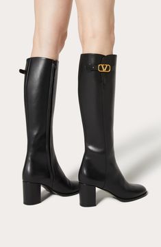 Valentino's signature boot fastens at the top with a golden VLOGO pin buckle and is crafted in Italy from supple calfskin leather. Lifted by a block heel, this iconic boot is designed with a nonslip rubber half sole for all surfaces. 2 3/4" (70mm) heel (size 38.5) 15 1/4" shaft; 14 1/2" calf circumference Side zip closure Leather upper and lining/leather and rubber sole Made in Italy Designer Shoes Valentino Boots, Leather Knee Boots, Black Knees, Boot Pumps, Lady Dior, Boots Black, Valentino Garavani, High Boots, Knee High Boots