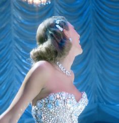 a woman in a beaded dress is looking up