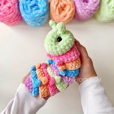 a hand holding a small crocheted stuffed animal