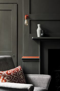 a living room with gray walls and orange accents