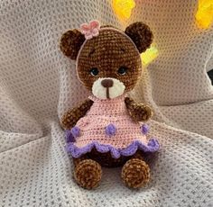 a teddy bear wearing a pink and purple dress