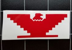 a red and white sticker on a tiled wall