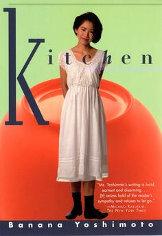 a woman standing in front of an orange vase with the word kithen on it