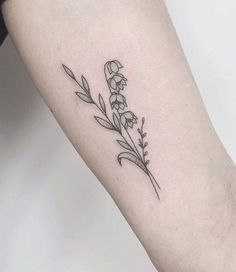 a small flower tattoo on the arm