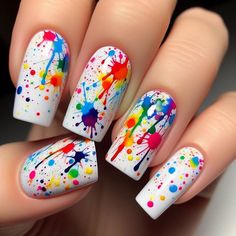 The nails are painted with a solid white base. Over this base, splatters of rainbow colors are randomly applied using a splatter technique. The result is a vibrant, abstract design that looks like a burst of color. A glossy top coat adds a smooth finish. Sneaker Nail Art, Smiley Face Design Nails, Black Paint Splatter Nails, Rainbow Nail Art Designs Bright Colors, Neon Paint Splatter Nails, Color Splash Nails, Neon Gel Nails Short, Splat Nails, 80s Nails Designs