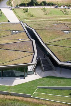 an aerial view of a building with grass on the roof and stairs leading up to it