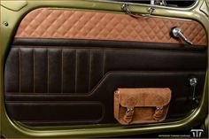 the interior of an old car with brown leather and tan stitching on the door panel