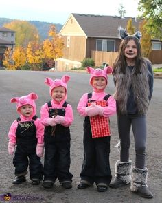 a woman standing next to three children wearing pink bunny ears and holding presents in their hands