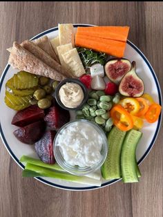 a white plate topped with different types of vegetables and dips on top of it