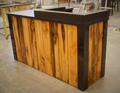 a counter made out of wood and metal in a room with construction tools on the floor