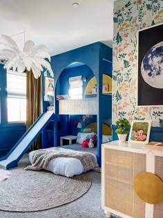 a child's bedroom with blue walls and floral wallpaper, a slide in the corner