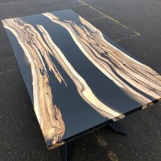 a table made out of black and brown marbled wood in the middle of a parking lot