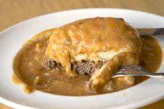 a close up of a plate of food with meat and gravy on it