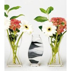 three vases with flowers in them on a table