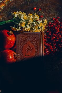 an open book surrounded by flowers and fruit