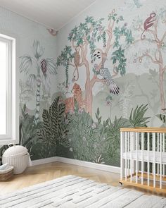 a baby's room with a wall mural and crib in the foreground