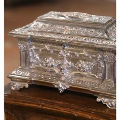 an ornate silver box sitting on top of a wooden table