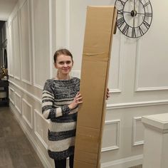 a woman standing next to a tall cardboard box