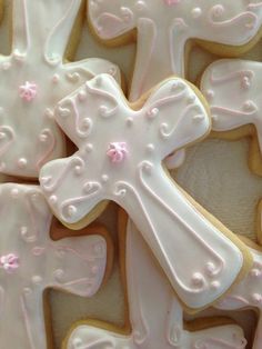 decorated cookies with white frosting and pink icing in the shape of a cross