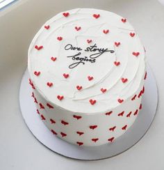 a white cake with red hearts on it