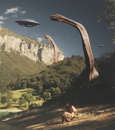 an image of two dinosaurs that are in the air with trees and mountains behind them