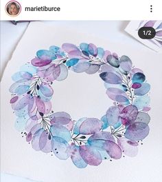 a watercolor wreath on top of a piece of paper