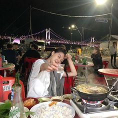 a woman sitting at a table covered in food