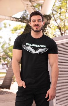 Our Philadelphia Eagle T-shirt is a stylish and comfortable option for devoted fans. This Cut and Sew Black T-shirt is designed to showcase your unwavering support for the Eagle while keeping you looking sharp. This Philly Teams Shirt is the perfect way to represent your love for Philadelphia football. This Game Day Shirt offers a soft feel and a relaxed fit, making it ideal for all-day wear. The cut-and-sew design provides a modern look that sets this shirt apart from the rest. With its short sleeves, this Football Shirt is perfect for layering or wearing on its own, ensuring you stay comfortable throughout the game. The bold Eagle graphic prominently displayed on the shirt is a fantastic way to show off your team spirit. This shirt is sure to catch the attention of everyone around you. I Fan Apparel T-shirt With Front Print, Front Print Cotton T-shirt For Fan Gear, Cotton T-shirt With Front Print For Fans, Fan Apparel Cotton T-shirt With Sublimation Print, Cotton Fan Apparel T-shirt With Sublimation Print, Cotton Sublimation Print Fan Apparel T-shirt, Black T-shirt With Sublimation Print For Fans, Band Merch Cotton T-shirt For Fans, Cotton Fan Apparel T-shirt With Front Print