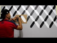 a man is painting a wall with black and white squares