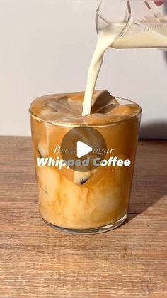 someone pouring coffee into a glass on top of a wooden table with the words whipped coffee