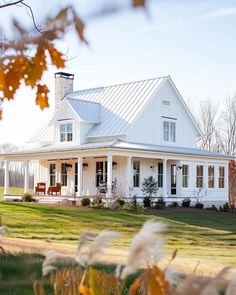 a white house sitting on top of a lush green field