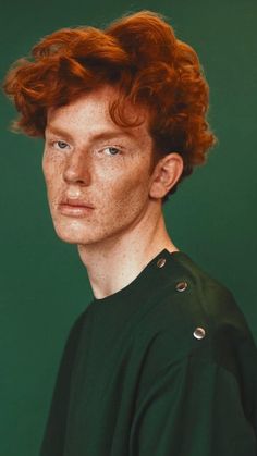 a young man with red hair wearing a green shirt