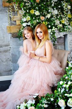 two women in pink dresses sitting on a couch