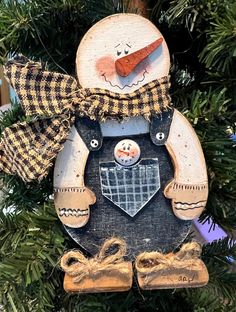 a snowman ornament hanging from a christmas tree