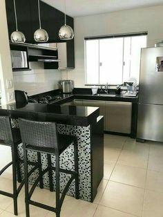 a kitchen with two bar stools next to an island