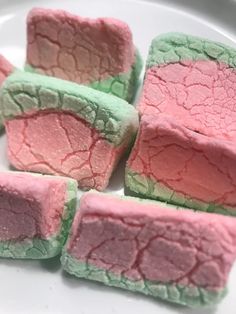 four pieces of pink and green cake on a white plate