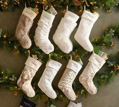 christmas stockings hanging on the wall with presents underneath them