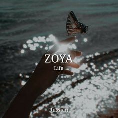 a person holding a butterfly in their hand with the words zoya life written on it