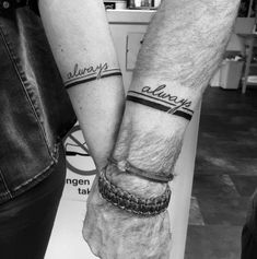 two people holding hands with tattoos on their arms and wristbands that say always