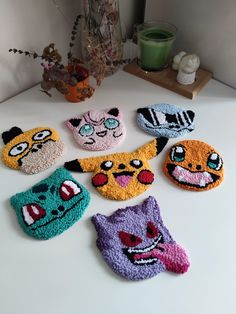 several knitted animal coasters sitting on top of a white table next to a plant