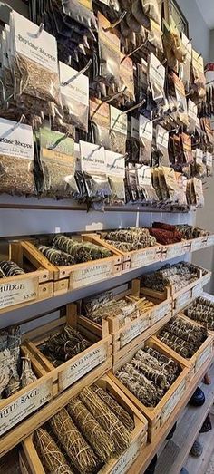 shelves filled with lots of different types of spices and herbs in wooden boxes on top of each shelf