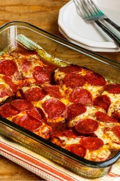 a pepperoni pizza casserole in a glass baking dish on a wooden table