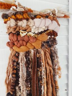 a wall hanging made out of different types of yarns and other things on it