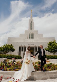 a bride and groom holding hands in front of the mormon temple on their wedding day