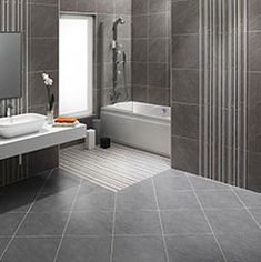 a modern bathroom with gray tile walls and floor, along with a white bathtub