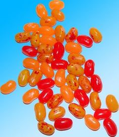 orange and red jelly beans against a blue background