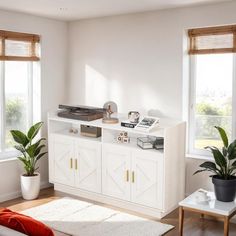 a living room with white furniture and plants in the window sill, along with two large windows