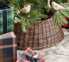 two birds are perched on the branches of a christmas tree, next to wrapped presents